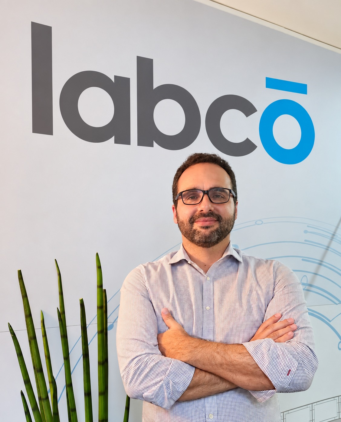 Labco Marine team member in the Limassol office, in front of the Labco logo