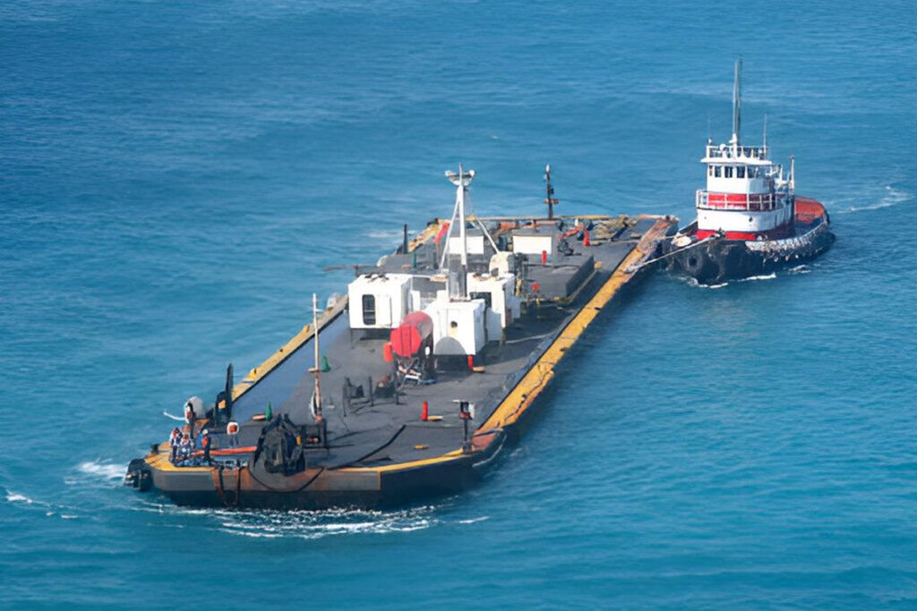 Tug manoeuvring a barge in open water