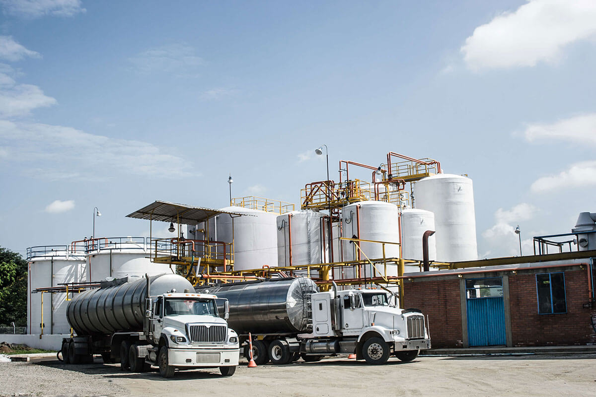 Tank trucks parked beside storage tanks at a Houston supply terminal